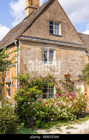 Fleurs d'été sur une pierre de Cotswold cottage dans le village de Stanway Bois, Gloucestershire UK Banque D'Images