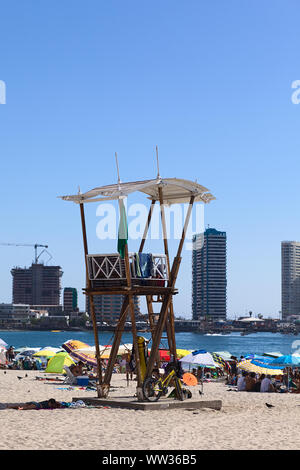 IQUIQUE, CHILI - 23 janvier 2015 : maître-nageur sur la plage de Cavancha guet avec des bâtiments modernes à l'arrière sur une péninsule, le 23 janvier, 2015 Banque D'Images