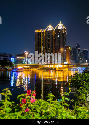 Kaohsiung, Taiwan : Skyline lumières de la ville et pont illuminé se reflétant dans l'amour, à la nuit noire Banque D'Images