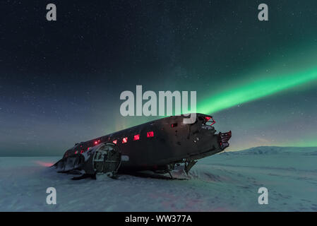 Feux du Nord sur l'épave de l'avion en Islande Banque D'Images