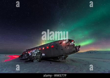 Feux du Nord sur l'épave de l'avion en Islande Banque D'Images