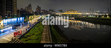 Panorama : Taipei Taipei vue depuis le pont en arc-en-ciel le long de la rivière Raohe. Big love rouge signe à Riverside Park avec les gens se détendre. Banque D'Images