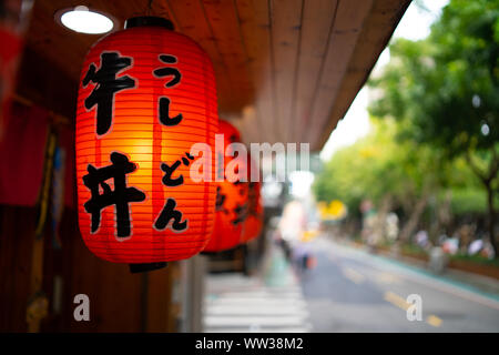 Taipei, Taïwan : lanterne traditionnelle japonaise l'écriture japonaise avec pendaison le Restaurant du trottoir dans petite rue avec arrière-plan flou Banque D'Images