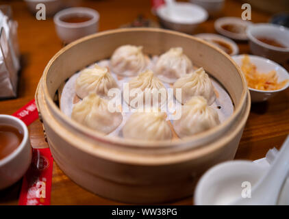 Taipei, Taïwan : le chinois traditionnel (soupdumplings Xiaolongbao) dans la région de bamboo steamer sur table de restaurant. Banque D'Images