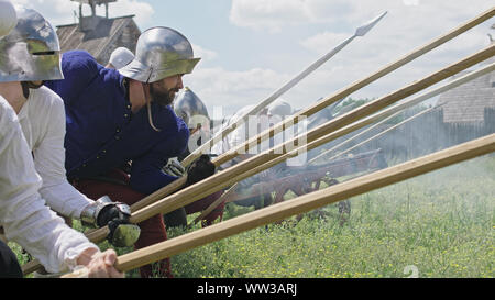 Chevaliers en offensive. La préparation de l'attaque des Guerriers et le artilleryist tirer du canon. Banque D'Images