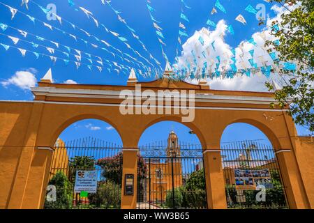 Décoration de drapeaux bleu et blanc accroché sur les rues de Puebla, Mexique. mois patriotique, décoration typique maison jaune et bleu ciel. Ils ont des traditions mexicaines : gastronomique, de l'architecture coloniale et la céramique. Carreaux talavera peintes ornent des édifices anciens. La cathédrale de Puebla, de style Renaissance, a une tour clocher donnant sur le Zocalo, la place centrale ou Place Zocalo. J'entre dans l'histoire. L'architecture est un UNESCO World Heritage Site. Attractions : Cathédrale, Temple de Notre-Dame de Concord, ancien collège Carolino, Bibliothèque Palafoxiana, Temple de Santo Domingo. (© P Banque D'Images