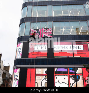 Artiste de rue, Alec Monoploy rappels en bas de la flanelle magasin sur Oxford Street, Londres à l'occasion de son lancement d'ouverture. Banque D'Images