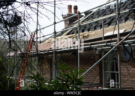 Échafaudage autour d'une maison victorienne pendant que des travaux sur le toit sont en cours Banque D'Images