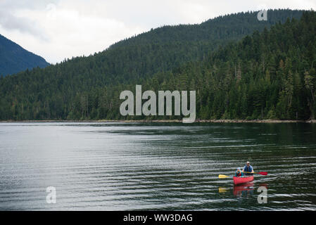 Homme et enfant d'un canot pagayer sur un lac de montagne Banque D'Images