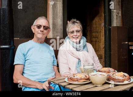 Portrait de couple plus âgé assis à un café de manger en voyage Banque D'Images