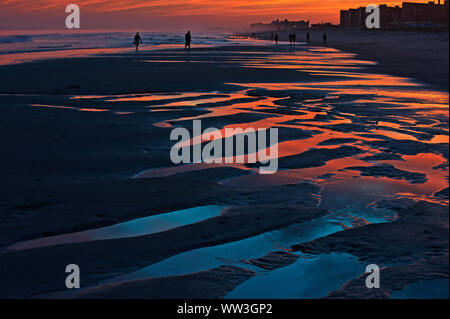 Rivage de soleil colorés avec des gens walking on beach Banque D'Images