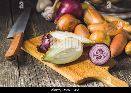 Oignons frais coupés en deux sur une planche à découper. Banque D'Images