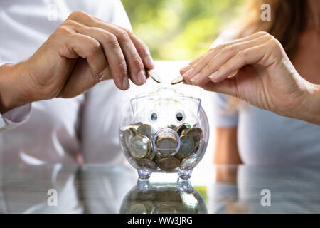 La mi-section de l'insertion de deux coins en Transparent Piggybank Banque D'Images