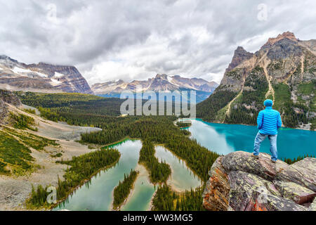 La fin de l'été randonneur sur haut de perspective Opabin surplombant le lac O'Hara et Mary Lake avec les Rocheuses en arrière-plan entouré de pois Wiwaxy Banque D'Images