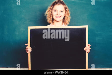 Bien fait, c'est notre devoir. femme professeur à tableau noir. copie espace. voici votre annonce. informations. conseil concept annonce. lieu d'écrire tâche. happy student girl tenir conseil en blanc. Banque D'Images