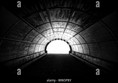 Noir et blanc spectaculaire avis d'un grand tunnel pour piétons bordée de vieilles planches en bois sur la surface de l'arche Banque D'Images