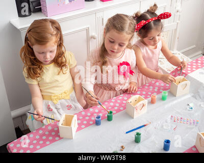 Petits jeunes filles faisant de l'artisanat à un anniversaire, UK Banque D'Images