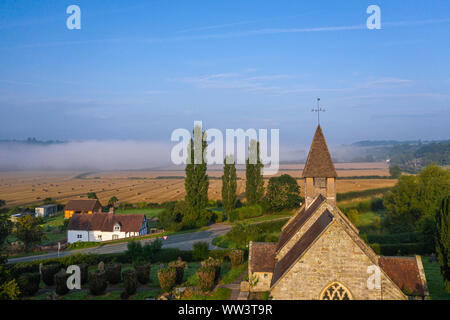 Vue aérienne sur un paysage pittoresque avec tour de l'église et misty champs en arrière-plan au lever du soleil. Le Shropshire en Royaume-Uni Banque D'Images