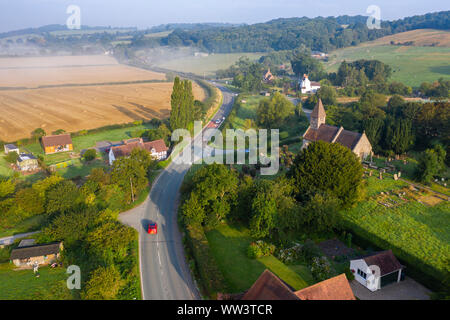 Vue aérienne sur la route à travers la campagne rural village au lever du soleil voilé. Le Shropshire en Royaume-Uni Banque D'Images