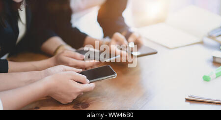 Close-up view of female pigistes partage de l'information sur smartphone pour les autres membres de l'équipe Banque D'Images