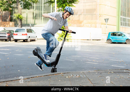 Homme qui tombe d'accident sur l'E-Scooter Street Banque D'Images