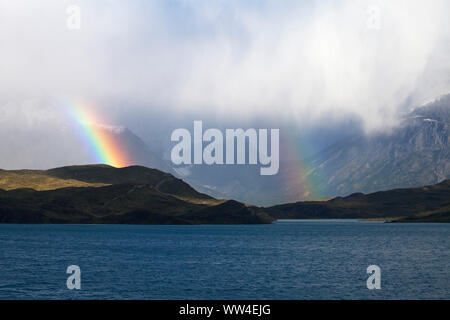 Arc-en-ciel sur une colline à côté le Lac Pehoe avec montagnes au-delà de Parc National Torres del Paine Les Andes Patagonie Chili Amérique du Sud Décembre 2016 Banque D'Images