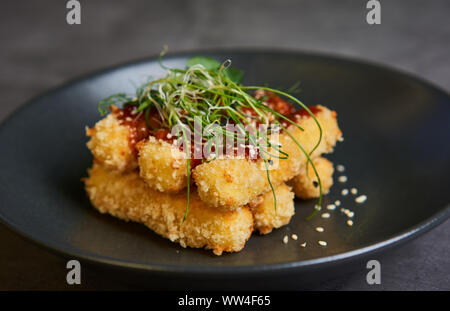 Bâtonnets de fromage pané avec la sauce sur une assiette Banque D'Images