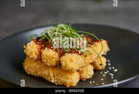 Bâtonnets de fromage pané avec la sauce sur une assiette Banque D'Images