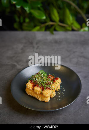 Bâtonnets de fromage pané avec la sauce sur une assiette Banque D'Images