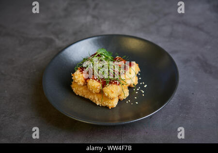 Bâtonnets de fromage pané avec la sauce sur une assiette Banque D'Images