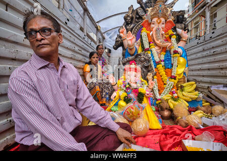 Au cours de la procession du Festival Ganesh à Mumbai, Inde, adorateurs de dieu éléphant Ganesh (Ganpati) monter sur un véhicule avec statues de Ganesh Banque D'Images