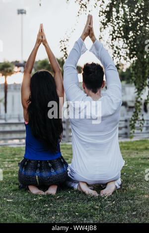 Homme de race blanche et femme latine méditer dans un parc de Madrid. La concentration et la détente en couple. Banque D'Images