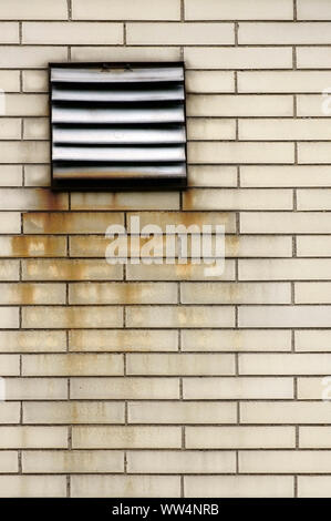 Photographie d'une grille de ventilation sur un mur de briques, et Rusty frappant Banque D'Images