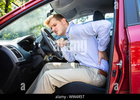 Comité permanent du pilote après avoir Backpain Driving Car Banque D'Images