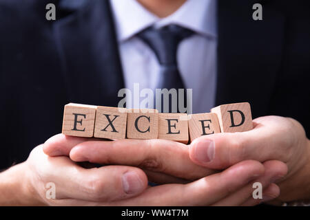Businessman Holding dépassent les attentes Mot dans ses mains Banque D'Images