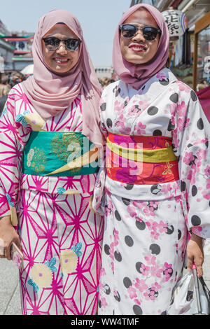 Asakusa, Tokyo, Japon. Deux jeunes femmes touristes visiter la région en tenue traditionnelle japonaise 'kimono' sourire à la caméra. Banque D'Images