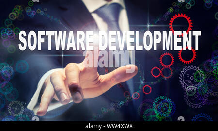 Un homme d'appuyer sur un concept d'entreprise de développement de logiciel sur un affichage graphique des cogs Banque D'Images
