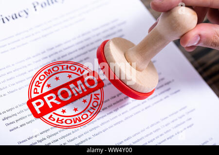 Businessman Hand Putting Promotion Stamp sur le document Banque D'Images