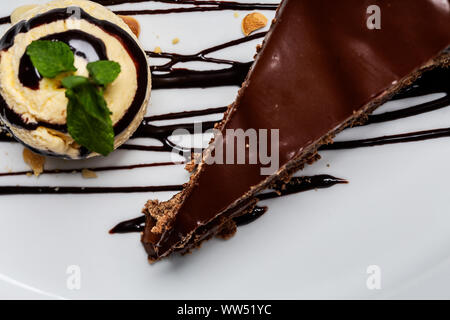 Balle jaune crème glace au chocolat avec garniture et tranche de gâteau au chocolat. Formant un dessert gastronomique. Vue de dessus. Banque D'Images