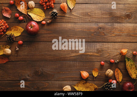 Cadre d'automne de feuilles d'automne, pommes, fruits rouges, noix sur table en bois. Thanksgiving, Halloween, concept la récolte d'automne. Télévision jeter compos Banque D'Images