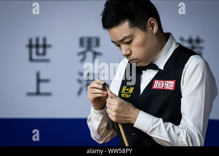 Ding Junhui de Chine les craies son cue lors du match contre Neil Robertson de l'Australie à la deuxième série de Snooker 2019 Masters de Shanghai à Shanghai, Chine, le 11 septembre 2019. Banque D'Images