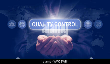 Businessmans creux des mains tenant un concept d'entreprise de contrôle de la qualité sur un écran informatique. Banque D'Images