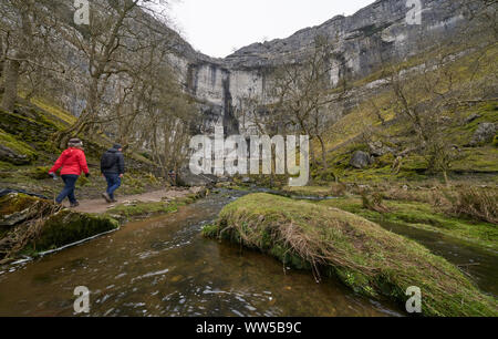 MALHAM COVE, Yorkshire, Angleterre, Royaume-Uni - 18 février. Les touristes à marcher en direction de la base de Malham Cove dans le Yorkshire Dales Banque D'Images