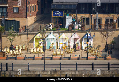 NEWCASTLE Upon Tyne, Angleterre, Royaume-Uni - Mai 08, 2018 : Thomas Cook sur la mer avec plage de sable artificielle, de transats et de cabines colorées Banque D'Images