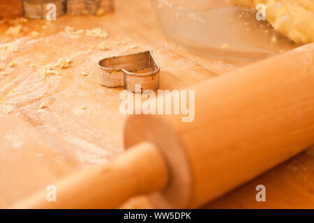 Emporte-pièce en forme de coeur sur table en bois à côté des rouleaux de crêpes Banque D'Images