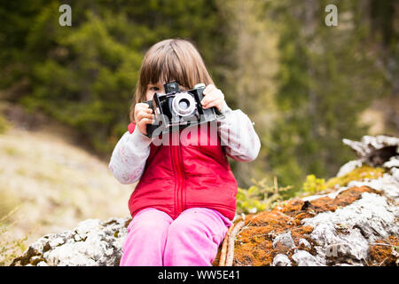 3-6 ans Girl in red waistcoat prendre des photos avec un ancien appareil photo Banque D'Images