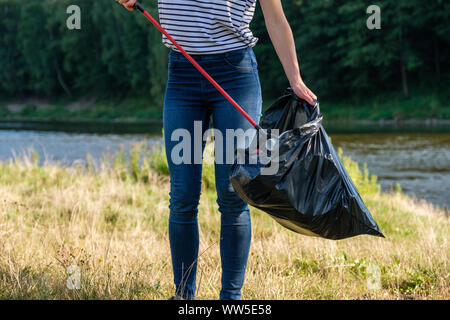 Femme bénévole ramasser des déchets en plastique sur la plage. Concept de l'environnement de nettoyage Banque D'Images