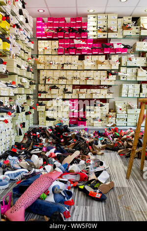 Boutique avec des boîtes à chaussures dans l'étagère et de chaussures sur le sol Banque D'Images