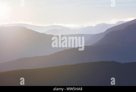 La chaleur du soleil en rampant sur un froid matin brumeux sur les lignes de crête de la Derwent Fells dans le Lake District, UK. Banque D'Images