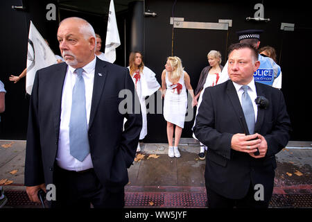Londres, Royaume-Uni. 13 Sep, 2019. Extinction des militants de la rébellion en robes blanches et 'âmes sensibles' eux-mêmes , à l'entrée principale de la London Fashion Week. D'autres membres de l'extinction de la rébellion versé seaux faux sang autour de l'entrée et a mené un', appelant à l'industrie de la mode de dire la vérité à propos de sa contribution à la crise écologique et climatique : Gareth Morris Crédit/Alamy Live News Banque D'Images